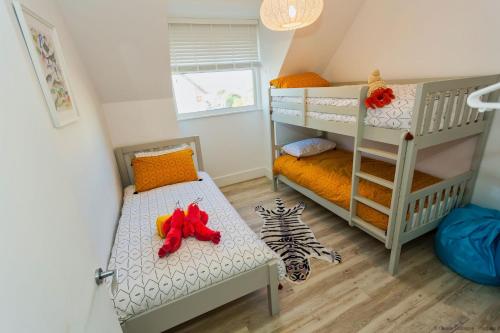 um quarto com 2 beliches e uma escada em WOOLACOMBE SUNNYSIDE APARTMENT 2 Bedrooms em Woolacombe