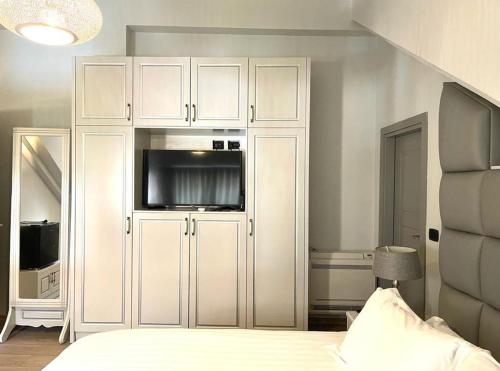 a bedroom with a large white cabinet with a tv at Vila Shard Boutique Hotel in Tirana