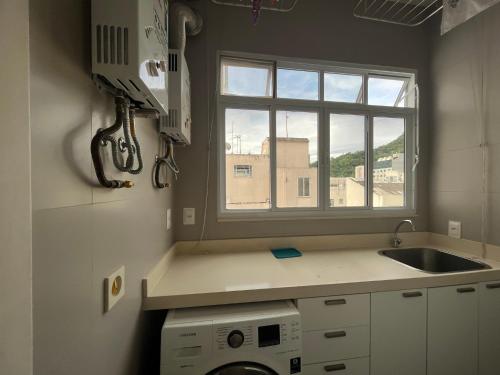 Elle comprend une petite cuisine avec un évier et une fenêtre. dans l'établissement Copa Paradiso, à Rio de Janeiro