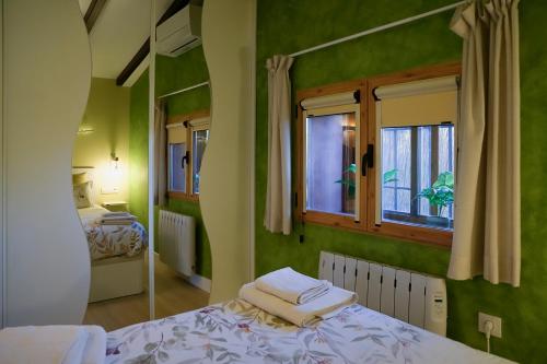 een groene kamer met een bed en een raam bij Casa Rural Manitoba Luxe in Buenache de la Sierra