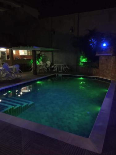 a swimming pool at night with green lights at Pousada Cambucá de Cabo Frio in Cabo Frio
