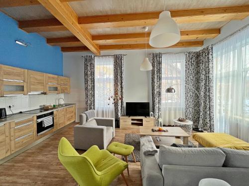 a kitchen and living room with a couch and chairs at Mountain View in Krynica Zdrój