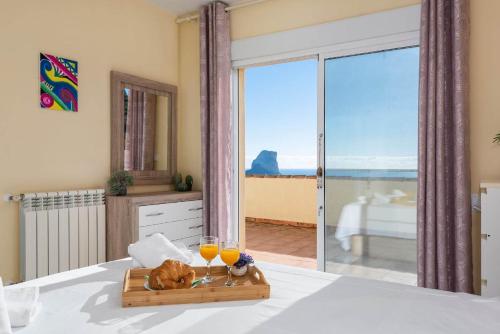 a bed with a tray of food and two glasses of orange juice at Villa Sabita - PlusHolidays in Calpe