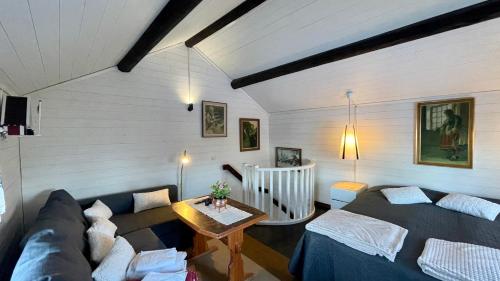 een woonkamer met een bank en een tafel bij Prinsgården B&B rum stugor in Mora