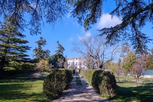un sentiero davanti a una casa con siepi di Cottage provencal - Villa saint Marc a Forcalquier
