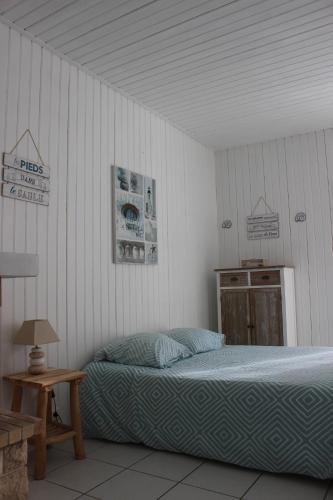 une chambre avec un lit et une table en bois dans l'établissement GITE AVEC SPA ENTRE FORET ET PLAGE - Ambiance Bord de Mer, à Saint-Hilaire-de-Riez
