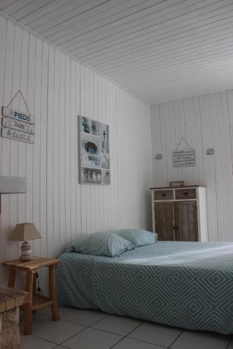 サンティレール・ド・リエにあるSTUDIO ENTRE FORET ET PLAGE - Ambiance Bord de Merのベッドルーム1室(ベッド1台、木製テーブル付)