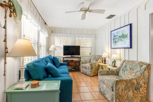 a living room with a blue couch and chairs at The Seashell Cottage in Anna Maria