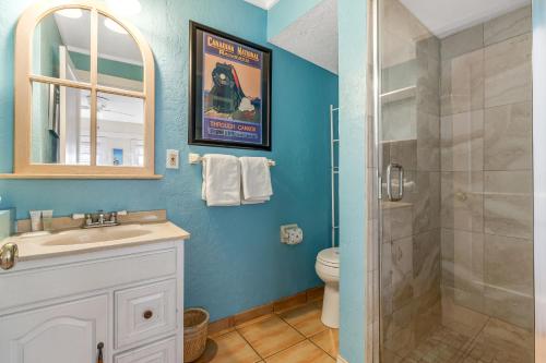 a bathroom with a shower and a sink and a toilet at The Seashell Cottage in Anna Maria