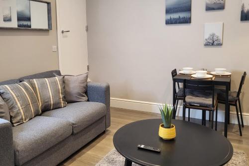 a living room with a couch and a table at Park House Modernised 2 Bedroom Property in Knowsthorpe