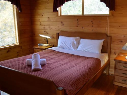 a bedroom with a bed in a log cabin at Coles Bay House in Coles Bay