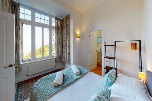 a bedroom with a bed and a large window at WOODY BAY FALLING WATER 2 Bedrooms in Lynton