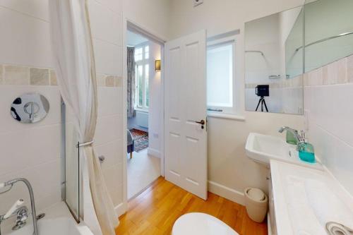 a white bathroom with a toilet and a sink at WOODY BAY FALLING WATER 2 Bedrooms in Lynton