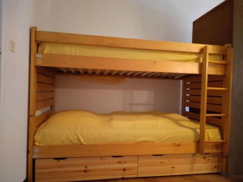 Ce lit superposé se trouve dans un dortoir doté d'un lit jaune. dans l'établissement Papillon, à Lit-et-Mixe