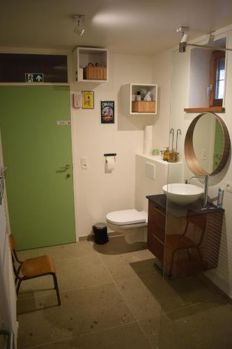 La salle de bains est pourvue de toilettes, d'un lavabo et d'un miroir. dans l'établissement B&B Houten Huis, à Nazareth