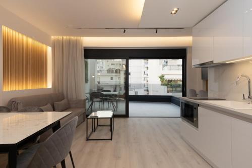 a kitchen and living room with a couch and a table at Incanto Boutique Suites - Neos Kosmos in Athens