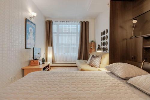 a bedroom with a large bed and a couch at Initial / Aube / Québec in Quebec City