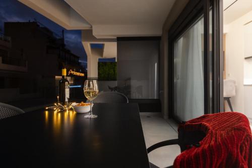 a table with a glass of wine and a chair at Incanto Boutique Suites - Neos Kosmos in Athens