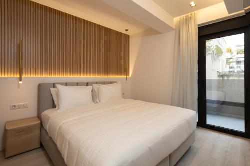 a bedroom with a large white bed and a window at Incanto Boutique Suites - Neos Kosmos in Athens