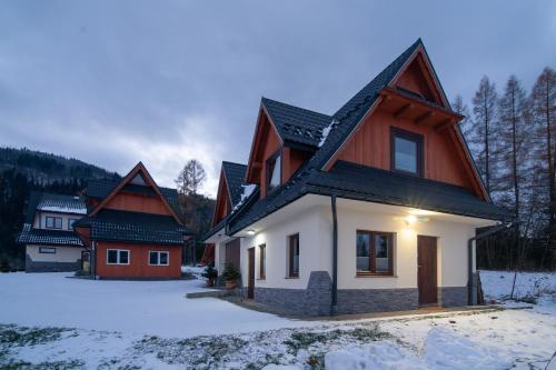 una casa en invierno con nieve en el suelo en Oczko Na Giewont, en Kościelisko