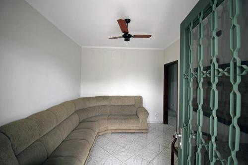 a living room with a couch and a ceiling fan at Casa de Temporada Gagiges in Olímpia