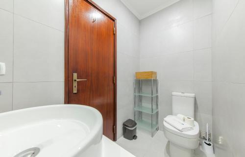 baño con aseo blanco y puerta de madera en N - Astonishing Bay View Guesthouse, en Lagos