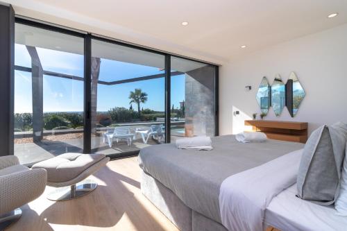 a bedroom with a large bed and a balcony at Casa Luna Mar in Estômbar
