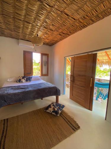 ein Schlafzimmer mit einem Bett und einem großen Fenster in der Unterkunft Casa Nature Atins in Atins