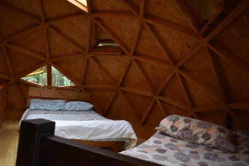 een kamer met 2 bedden in een driehoekige kamer bij cabaña tipo domo 100% equipado in Nobsa