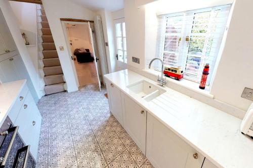 eine Küche mit einem Waschbecken und einem Fenster in der Unterkunft CROYDE VICTORIA COTTAGE 2 Bedrooms in Croyde