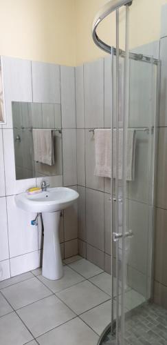 a bathroom with a sink and a shower at Manzini, Park Vills Apartment, No 103 in Manzini