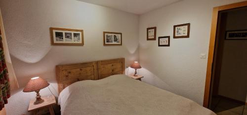 a bedroom with a bed and three pictures on the wall at Chalet Casteol in Champoussin