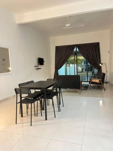 a dining room with a black table and chairs at Homestay Kemaman Fyna04 dekat Pantai Geliga in Kemaman