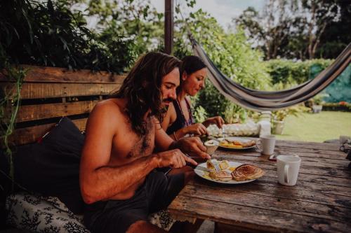 two men sitting at a picnic table eating food at Bodhi El Valle in Valle de Anton