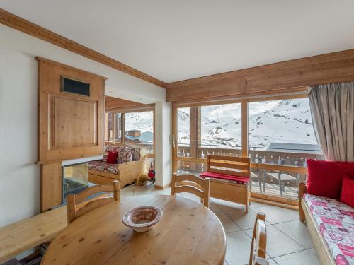 - un salon avec une table et une vue sur les montagnes dans l'établissement Appartement Confortable 6 Pers. Proche des Pistes avec Balcon et Parking - FR-1-640-11, à Val Thorens