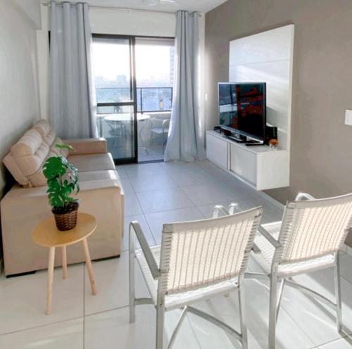sala de estar con sofá y TV en Apartamento novinho 2 quartos Ponta Verde, en Maceió