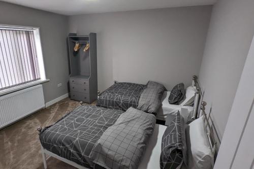 a bedroom with two beds and a tv in it at Modernised 4 Bedroom Property Close To City Centre, Harehills Lane in Roundhay