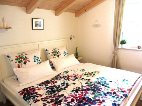 una camera da letto con un letto con copriletto floreale di Ferienwohnung Schrödel a Aschau im Chiemgau