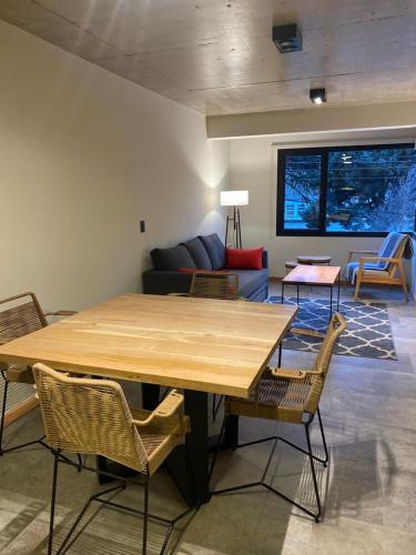 una sala de estar con una gran mesa de madera y sillas en AIKEN 9 SOL en San Martín de los Andes