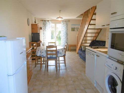 une cuisine et une salle à manger avec une table et des chaises dans l'établissement Maisonnette Youenn, à Sarzeau