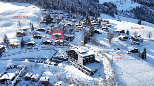 an aerial view of a resort in the snow at Ski-in & Ski-out out Chalet Maria with amazing mountain view in Maria Alm am Steinernen Meer