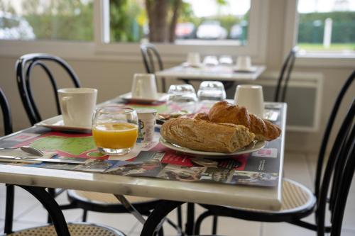 a table with a plate of bread and orange juice at Fasthôtel Périgueux in Marsac-sur-lʼIsle