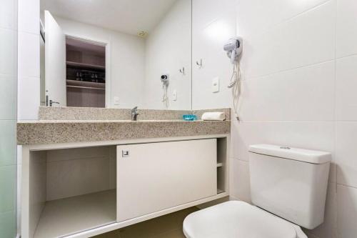 a white bathroom with a toilet and a sink at Cabo Frio - Loft Premium Royalle in Cabo Frio
