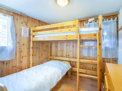 Ce lit se trouve dans un dortoir doté de 2 lits superposés et de murs en bois. dans l'établissement Charmant 3 pièces centre La Clusaz, 300m des pistes, balcon Sud, 6 pers, parking et ski à proximité - FR-1-437-84, à La Clusaz