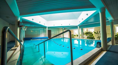 an indoor swimming pool with a blue ceiling at Health & Wellness Center Energetikas in Šventoji