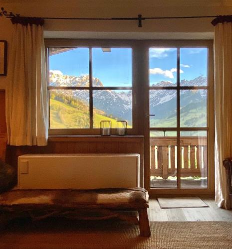 a room with a large window with a view of mountains at Ski-in & Ski-out out Chalet Maria with amazing mountain view in Maria Alm am Steinernen Meer