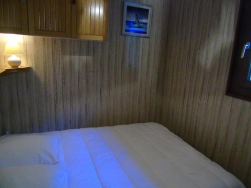 a bedroom with a white bed in a wooden wall at Appartement Châtel, 2 pièces, 4 personnes - FR-1-198-113 in Châtel