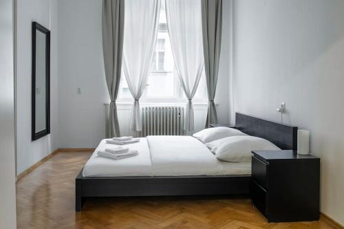 a bedroom with a bed and a large window at Prince Matyas apartment in Prague
