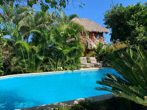 a resort with a swimming pool and a hut at Surfbreak B&B in Cabarete
