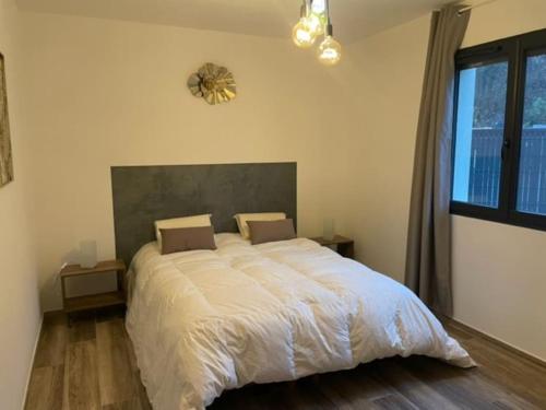 Schlafzimmer mit einem großen weißen Bett und einem großen Fenster in der Unterkunft Cassie Home in Saint-Jean-en-Royans